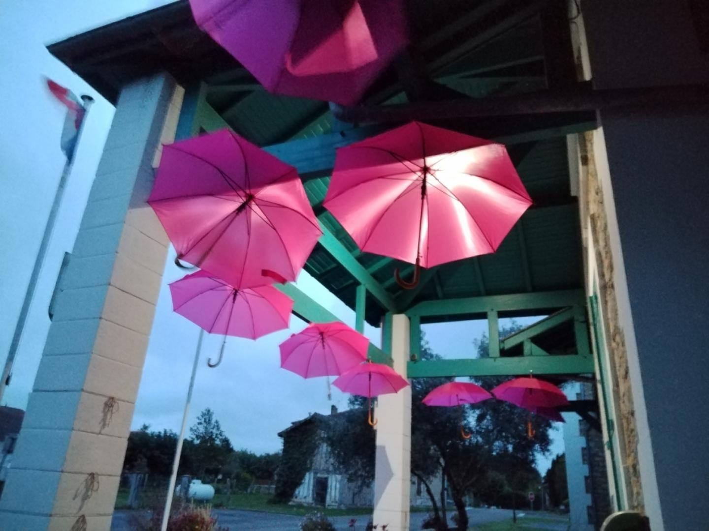 Parapluies roses suspendus à la mairie